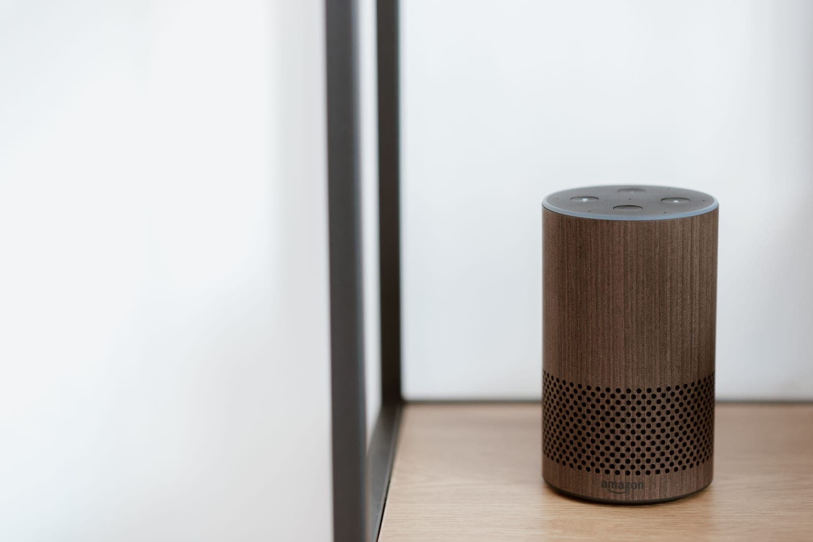 A calm, modern living room with a smart speaker, connected lighting and a control panel in warm daylight