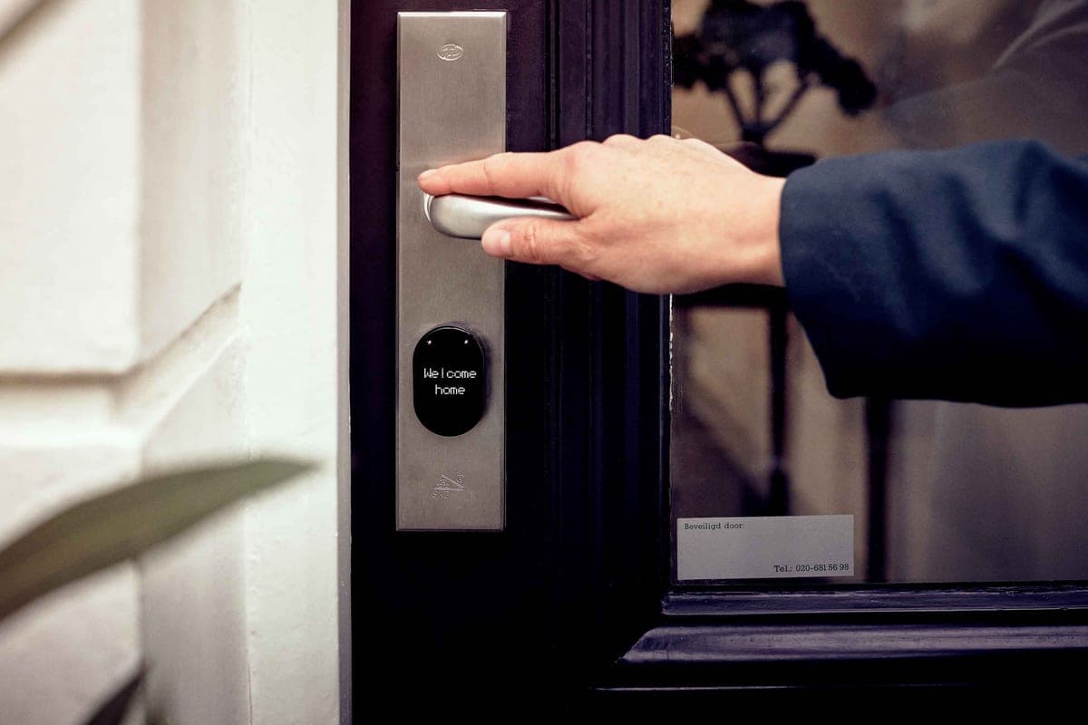 A smart deadbolt lock on a front door being opened with a phone